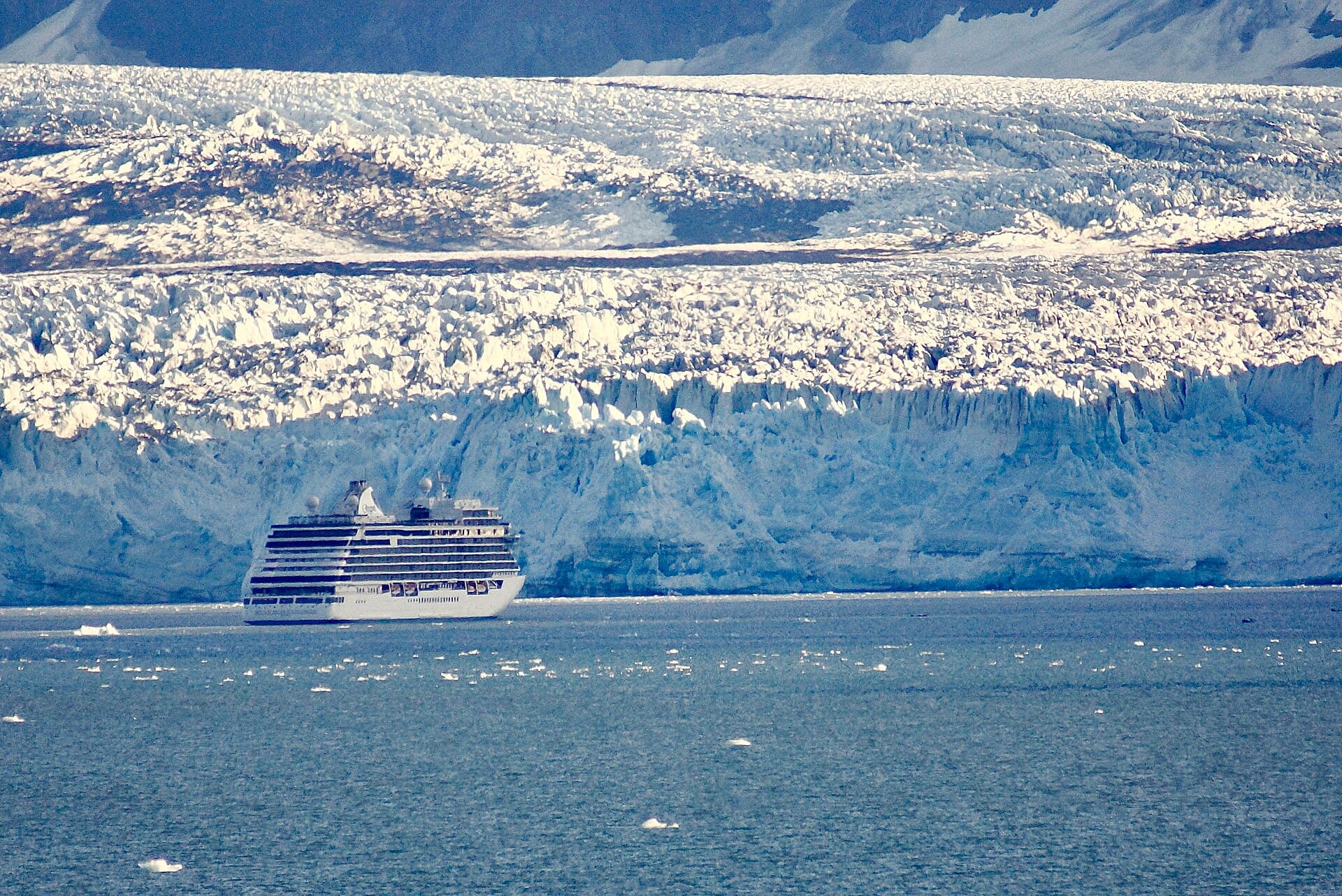 A cruise ship dwarfed by a retreating glacier in Glacier Bay, Alaska